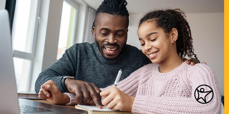 A father is helping his daughter study for an online school